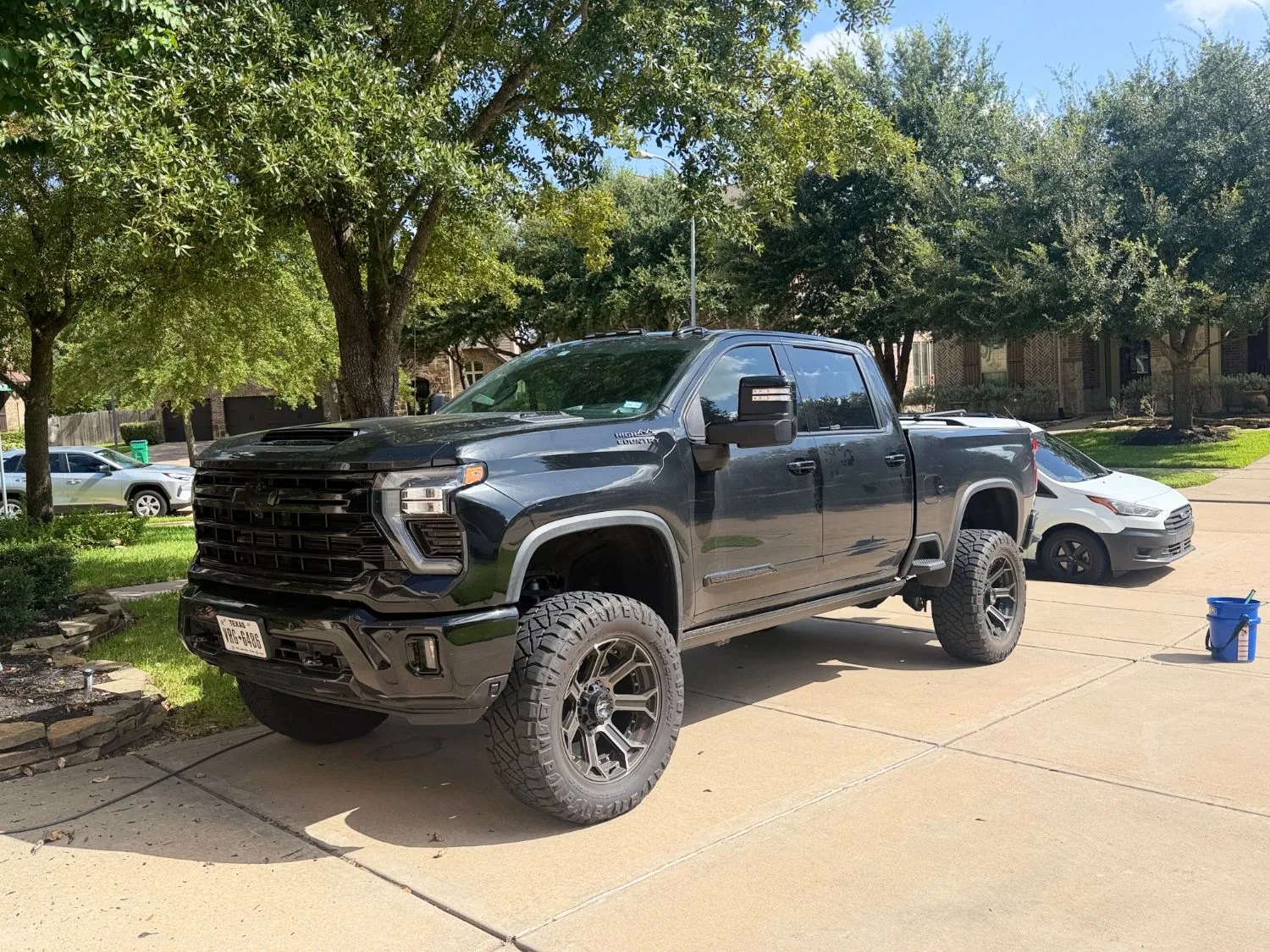 Lifted Silverado 2500 covered in road dust before detailing