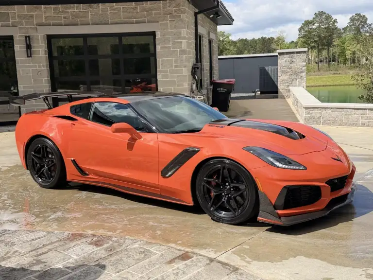 Orange Corvette ZR1 with a wet, glossy finish on a stone driveway